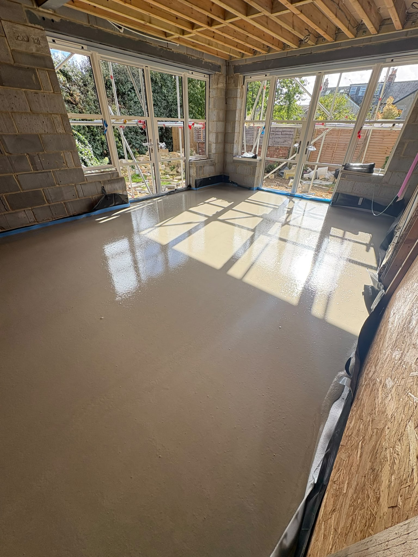 Liquid screed finished beneath full-height glazing