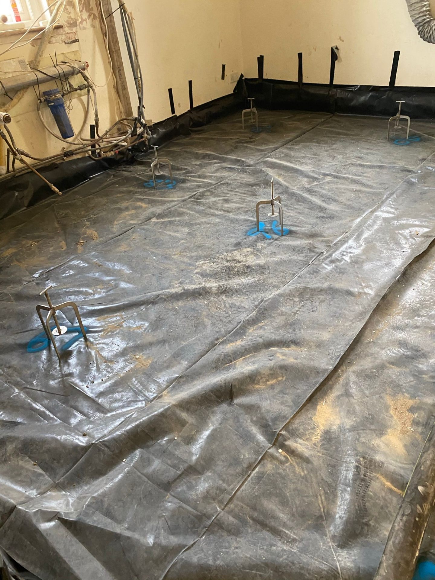 Pumped screed pour reaching design depth above heating pipes