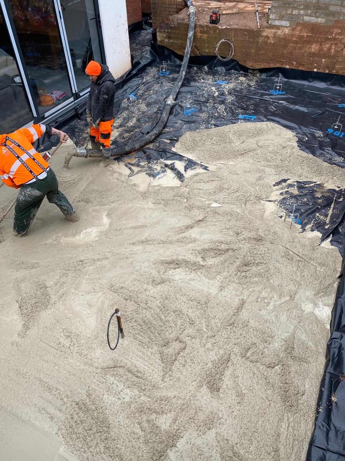 Crew levelling concrete around the perimeter of a slab