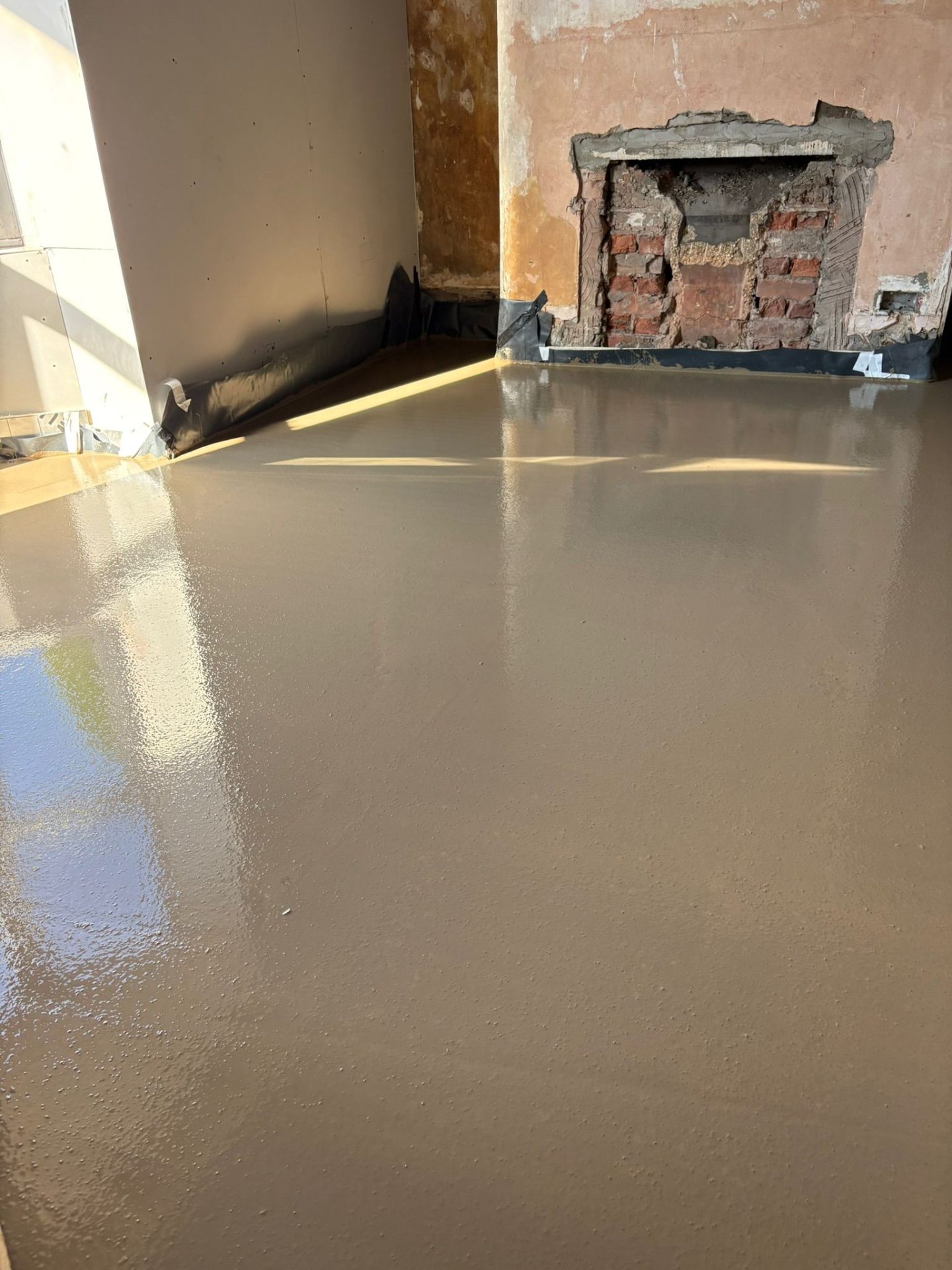 Flowing screed finished around a chimney breast over UFH