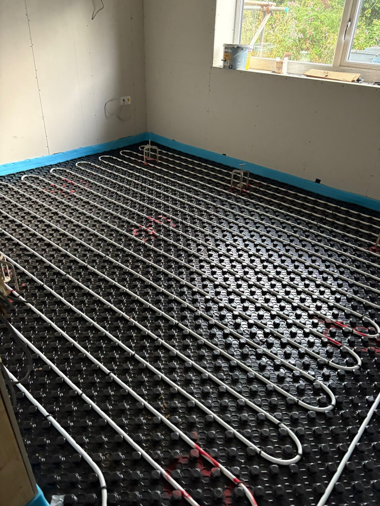 UFH pipework on dimpled mats in a snug room